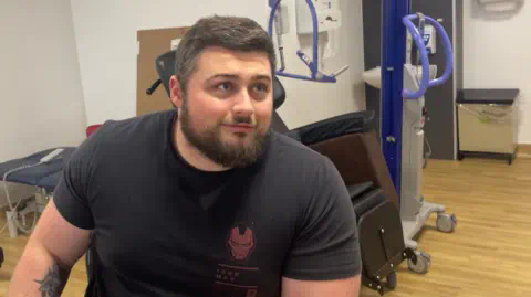 BBC Dan Jones sitting in a hospital room wearing a black t-shirt