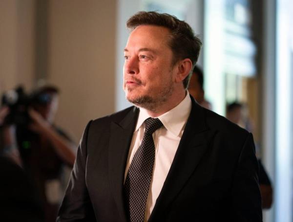 Elon Musk, CEO of Tesla, in a suit, speaking at the Artificial Intelligence Insight Forum